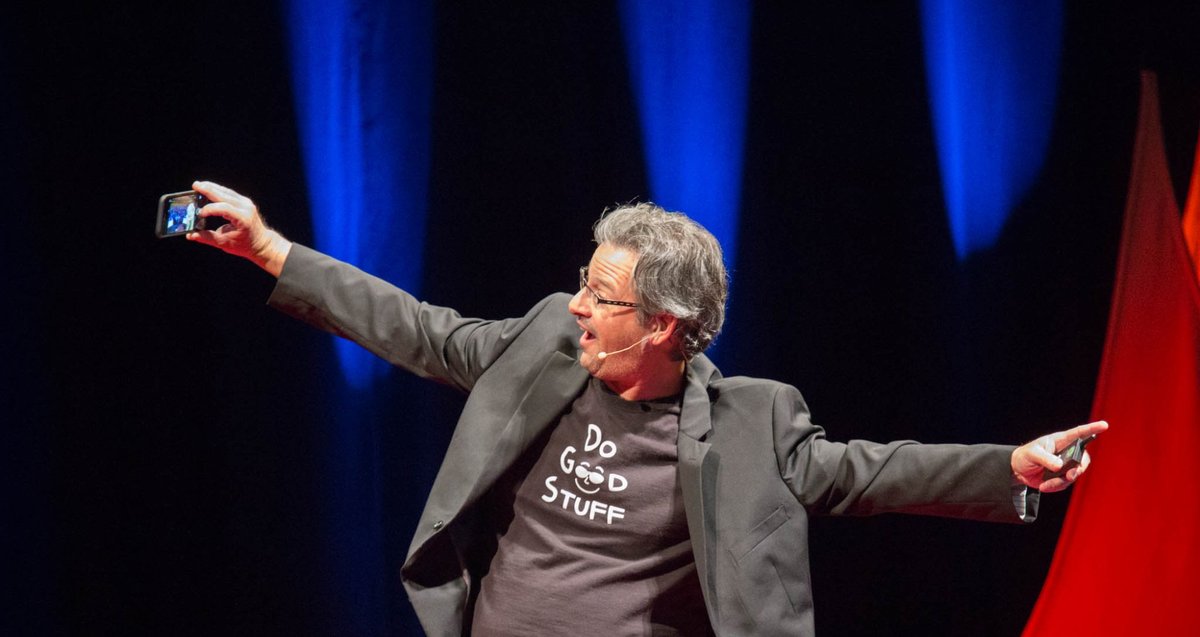 Joel Comm keynote speaker on stage arms wide